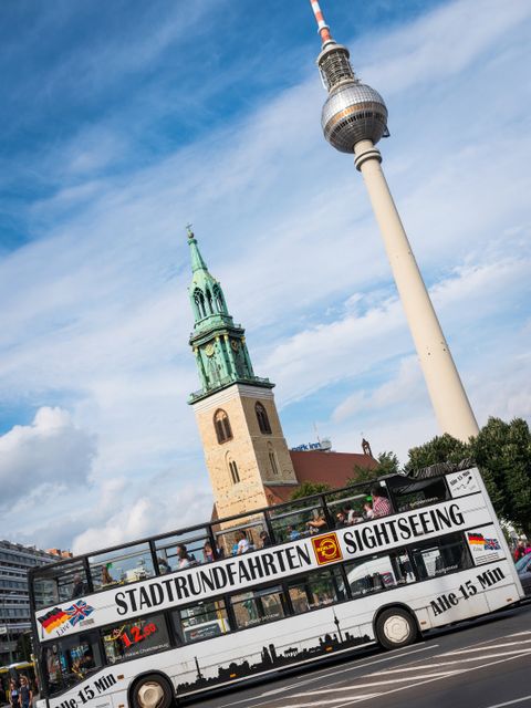 Stadtrundfahrt-Bus mit Fernsehturm und Marienkirche im Hintergrund