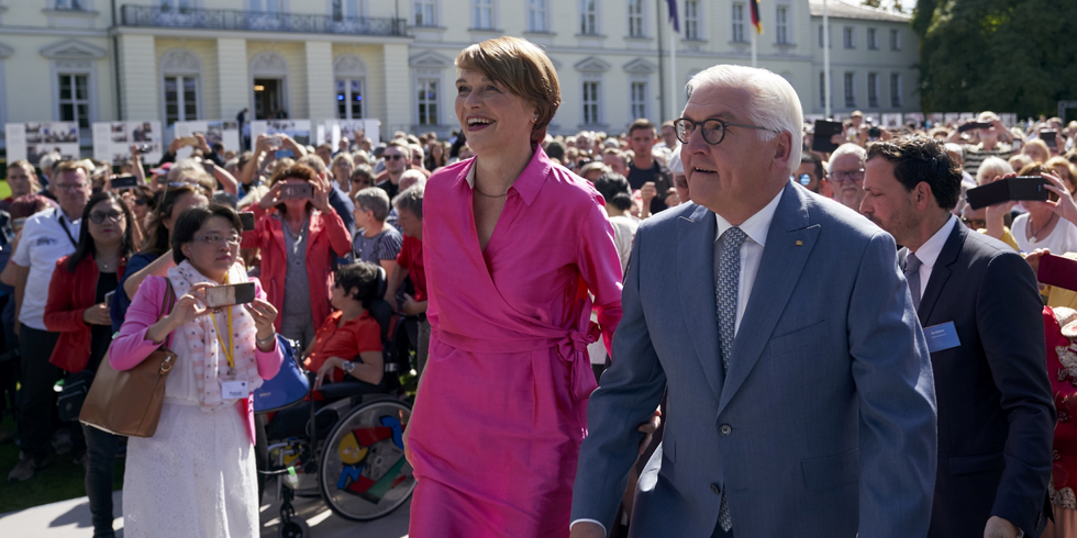 Bundespräsident Frank-Walter Steinmeier und seine Frau Elke Büdenbender mit einer Menschenmenge im Hintergrund vor dem Schloss Bellevue
