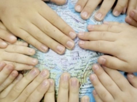 Kinderhände auf Globus - Globales Lernen