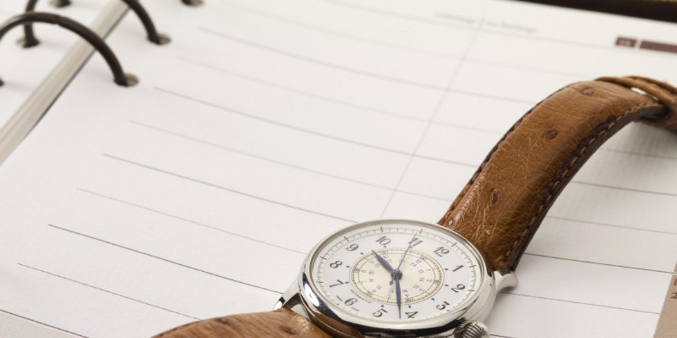 Eine Uhr liegt auf einem Terminplaner