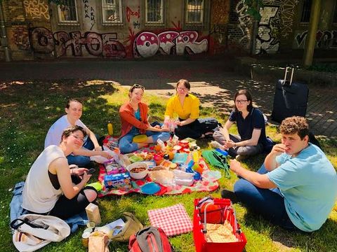 mehrere Personen sitzen bei einem Picknick