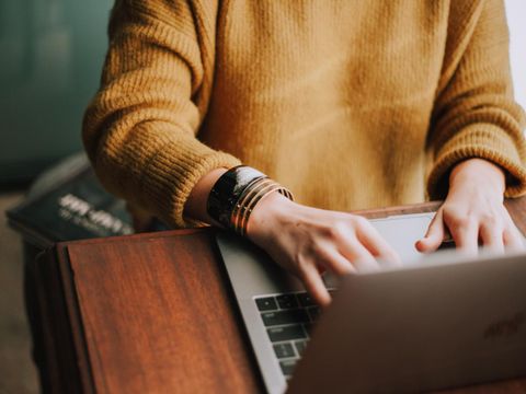Frau sitzt vor einem Laptop und recherchiert