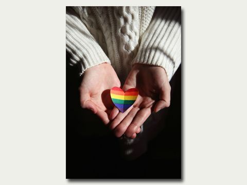 Zwei Hände halten ein Herz in Regenbogenfarben