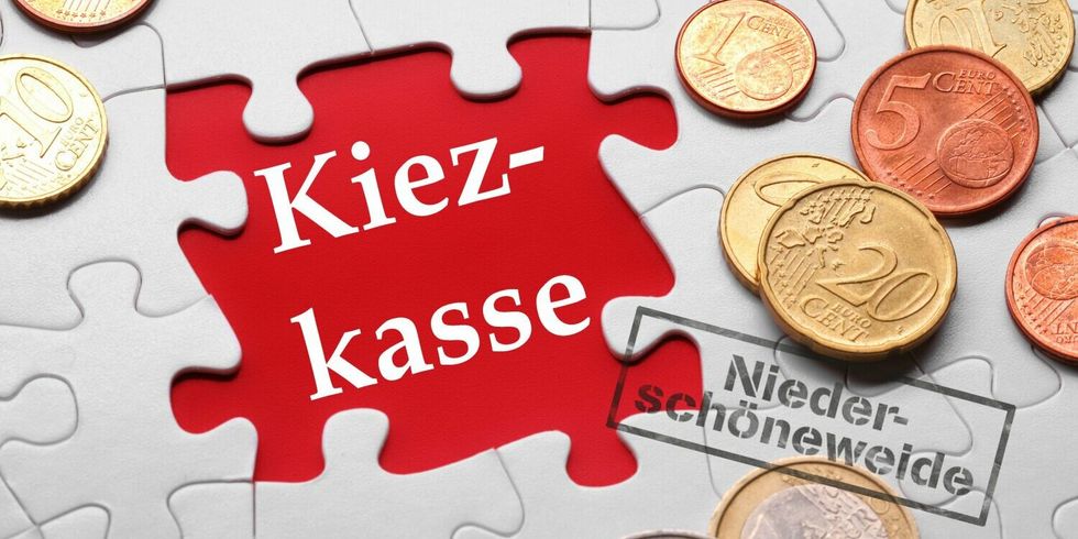 Münzen liegen auf einem Puzzle - Aufschrift Kiezkasse mit Stempel Allende-Viertel