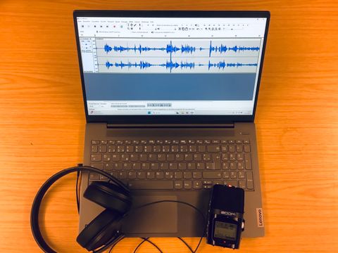 Foto von Laptop, Aufnahmegrät und Kopfhörer