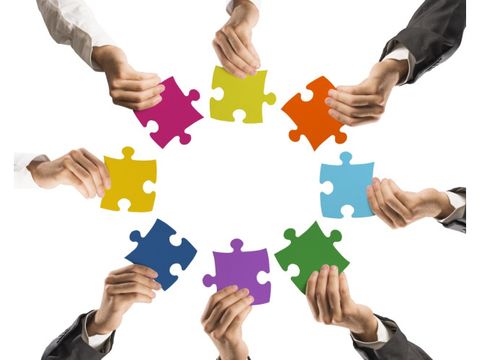 Hände mit Puzzleteilen bilden einen Kreis