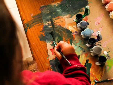 Kind malt mit Farbe und Karton