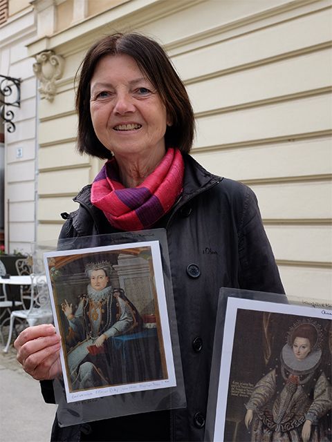 Stadtführerin Dr. Gerhild Komander hält die Porträts zweier Frauen aus dem 15. Jahrhundert hoch