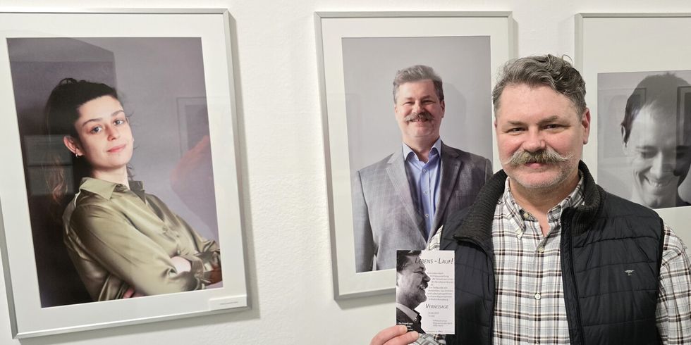 Fotografin Chloé Laurence Cohen (li.) und ein Mitschüler aus dem Berufssprachkurs zeigt vor seinem Portrait den Flyer der Ausstellung