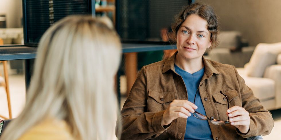 Eine Psychologin berät eine Klientin, während sie in ihrem Büro sitzt und aufmerksam zuhört und beobachtet.