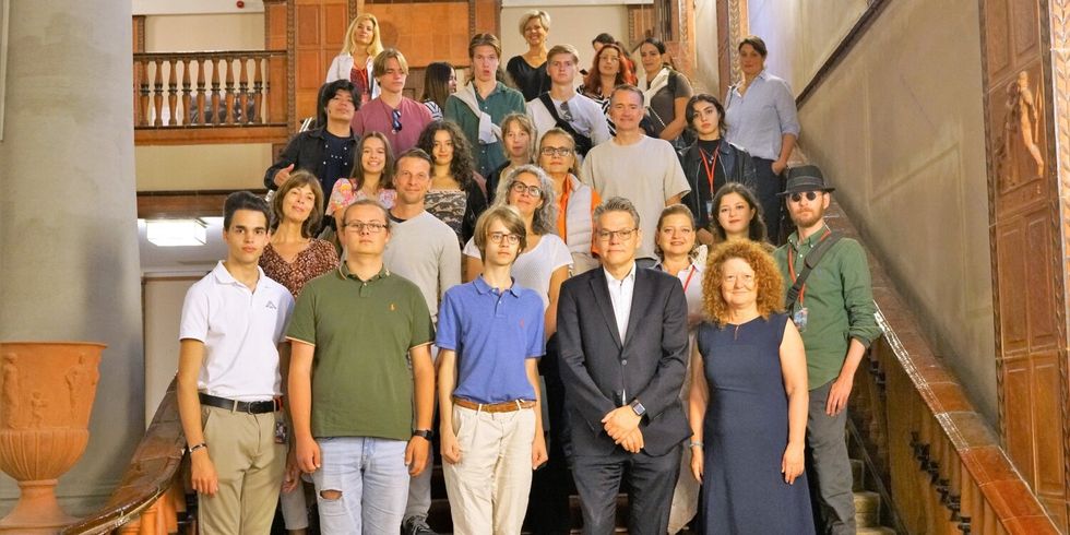 Eine Gruppe Menschen steht zusammen auf einer Treppe.