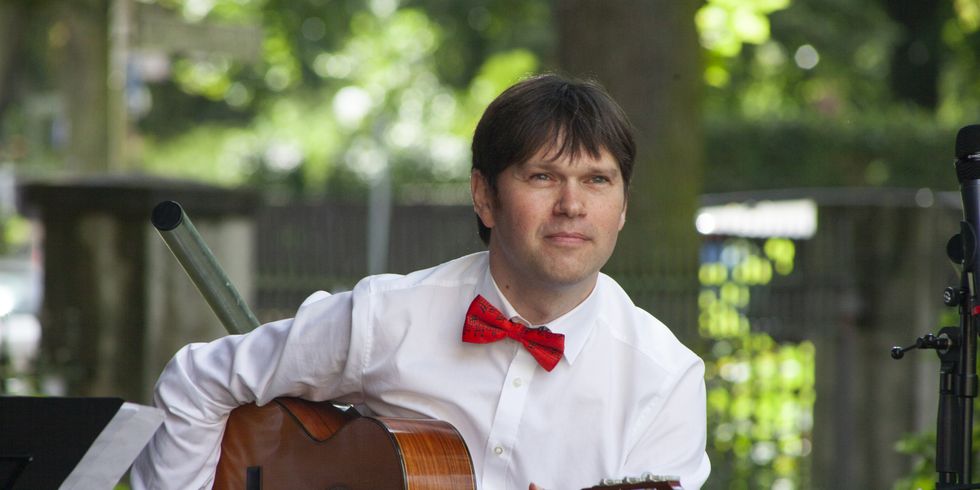Mann spielt Gitarre im Freien