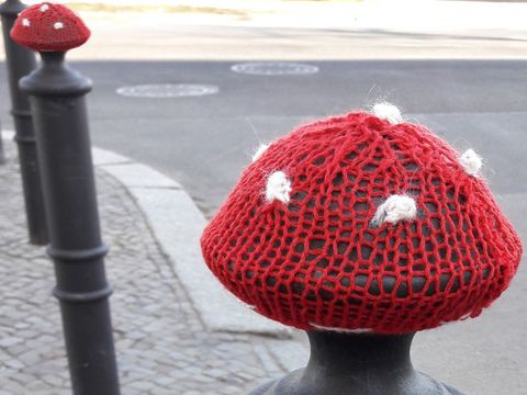 Garn-Attacke: Gestrickte Fliegenpilzhüte auf Straßenpollern. (Bild: © Jugendkunstschule Pankow)