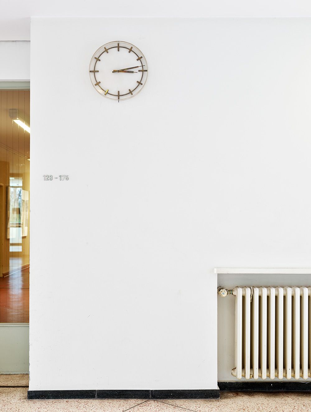 Bauzeitliche Uhr und Heizkörper im Foyer 1. OG, April 2020