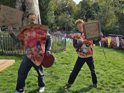 Zwei junge Aktivisten machen mit übergroßen Pizza-Kartons auf die Vermeidung von Verpackungsmüll aufmerksam