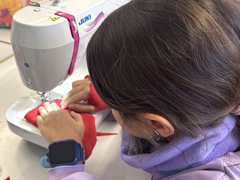 Modeatelier I & II: Ein Kind näht an der Nähmaschine. (Bild: © Jugendkunstschule Pankow)