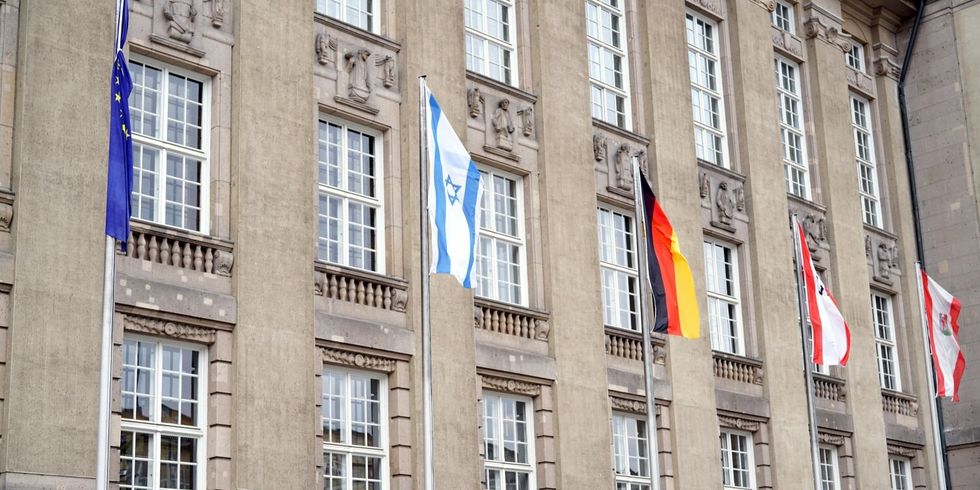 Fünf Flaggen hängen vor einem Gebäude; die EU-Flagge, die israelische Flagge, die deutsche Flagge, die Berliner Flagge und die Flagge von Tempelhof-Schöneberg.