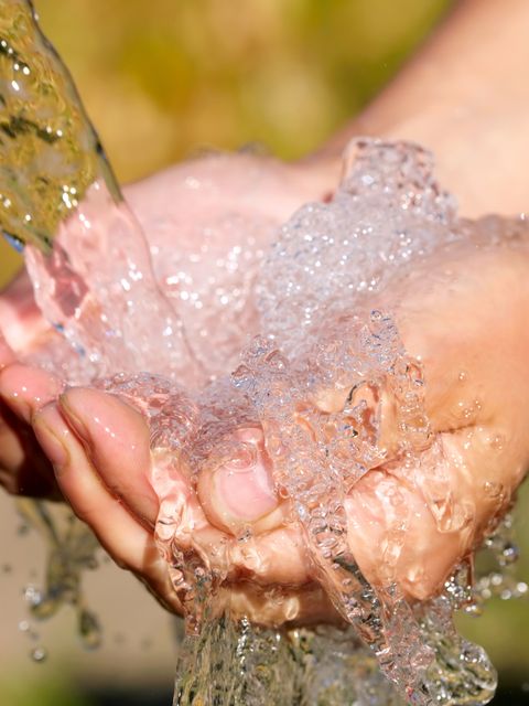 Hände werden unter einem Wasserstrahl gehalten
