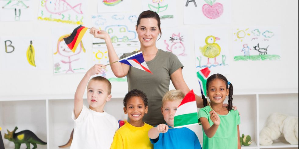Schulkinder winken mit Fähnchen