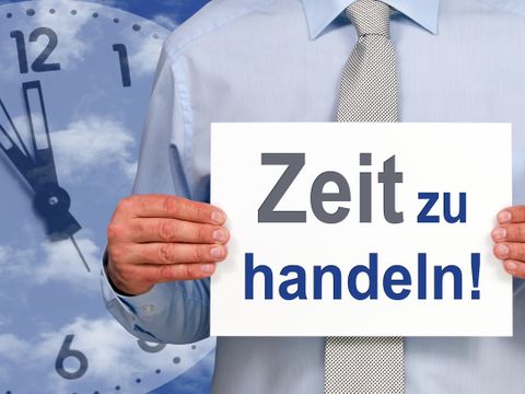 Mann hält in den Händen ein Schild mit der Aufschrift Zeit zu handeln