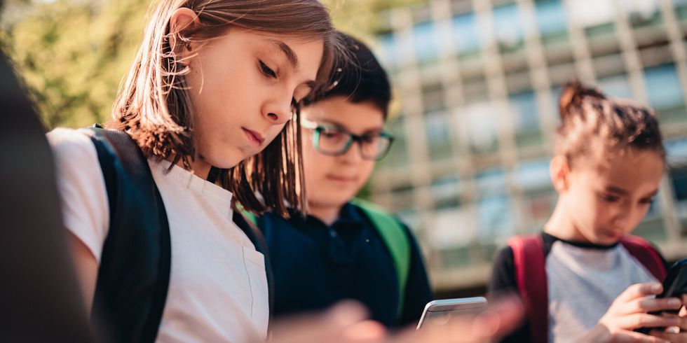 Eine Gruppe von Freunden in der Schule nutzt Smartphones