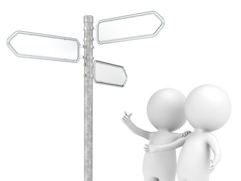 Zwei Personen schauen auf einen Wegweiser