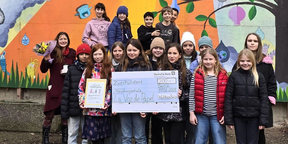 Die Schüler*innen der Friedrichshainer Hausburgschule zeigen den Gewinner*innen-Scheck über 200 Euro, den sie für ihre Schülerzeitungs-Arbeit erhalten haben