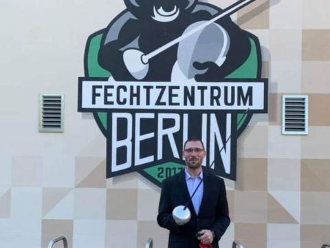 Michael Behrendt, 1. Vorsitzender des Fechtsportzentrums Berlin e.V vor der neuen Halle mit dem Logo