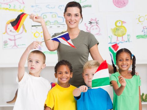 Schulkinder winken mit Fähnchen