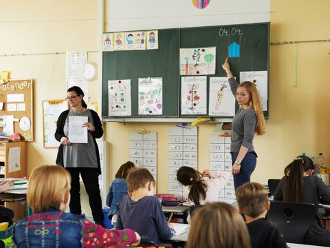 Lehrerin an der Tafel vor Klasse