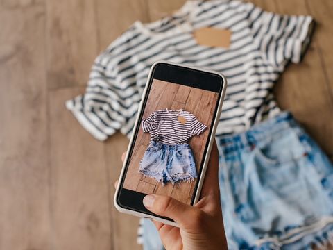 Frau fotografiert gebrauchte Kleidung.