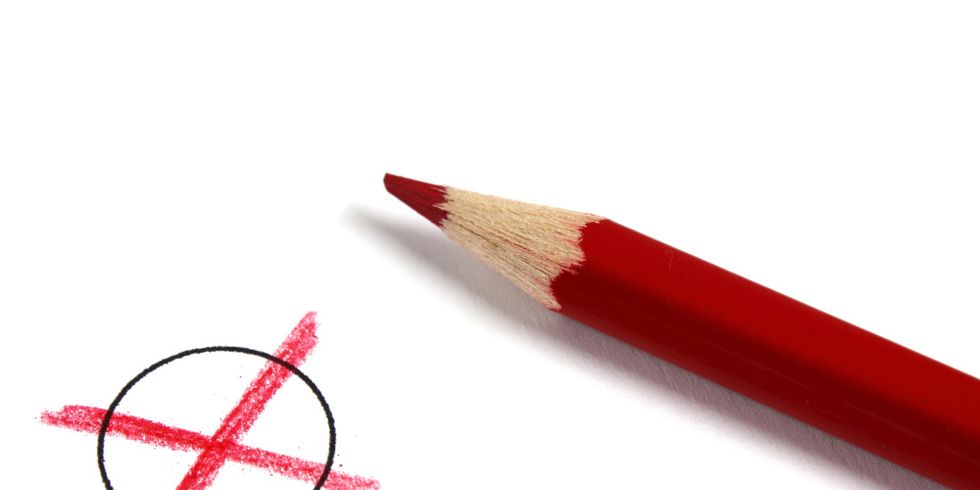 Ein roter Buntstift macht ein Kreuz in einem Kreis