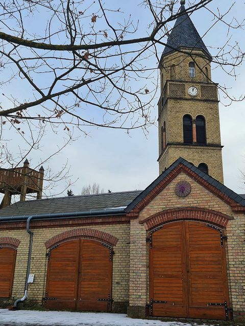 Wieder aufgebaute Feuerwehr (2004) mit Schlauchturm, Kirchturm (1847) der alten Dorfkirche von Friedrich August Stüler, Karow, 2026 (Bild: © Museum Pankow)