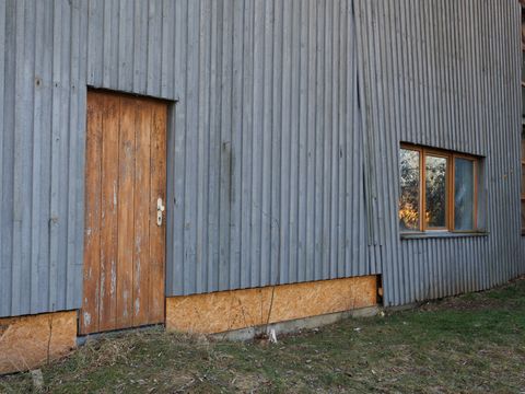 Zu sehen ist eine Holzfassade mit vielen Schäden.