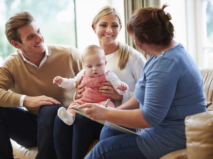 Gesundheitsbesucher sprechen mit jungem Baby mit der Familie