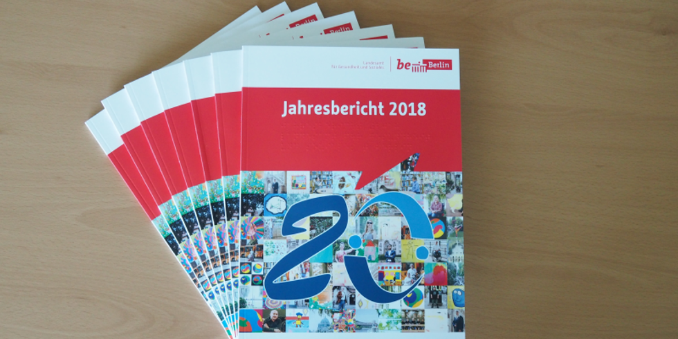 Auf einem Tisch liegen aufgefächert ein paar Exemplare vom Jahresbericht 2018