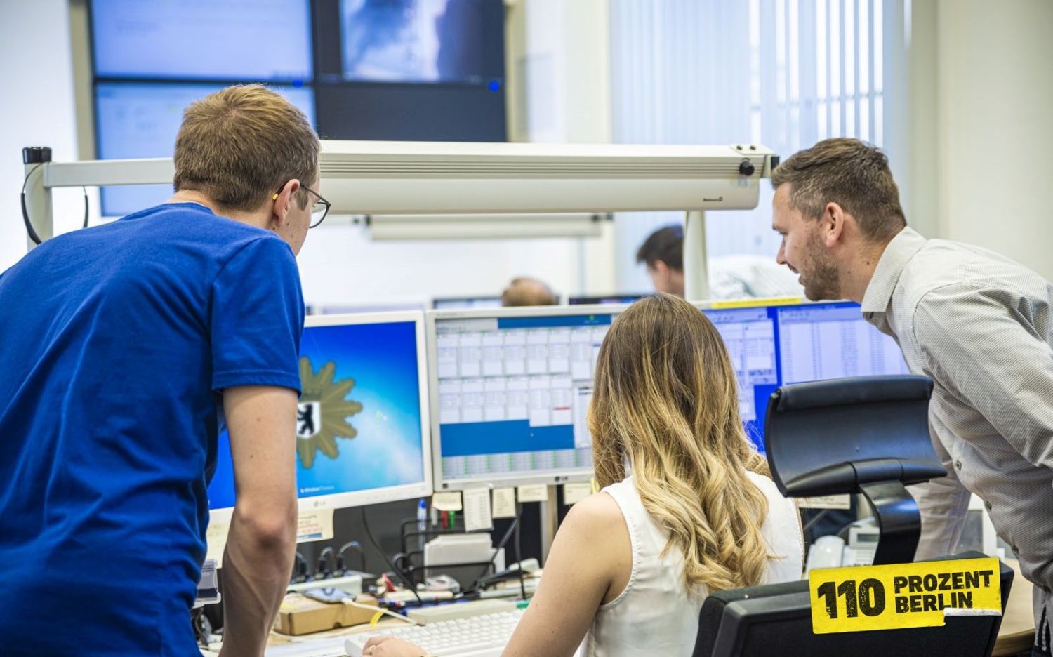 Mitarbeitende vor einem Computer