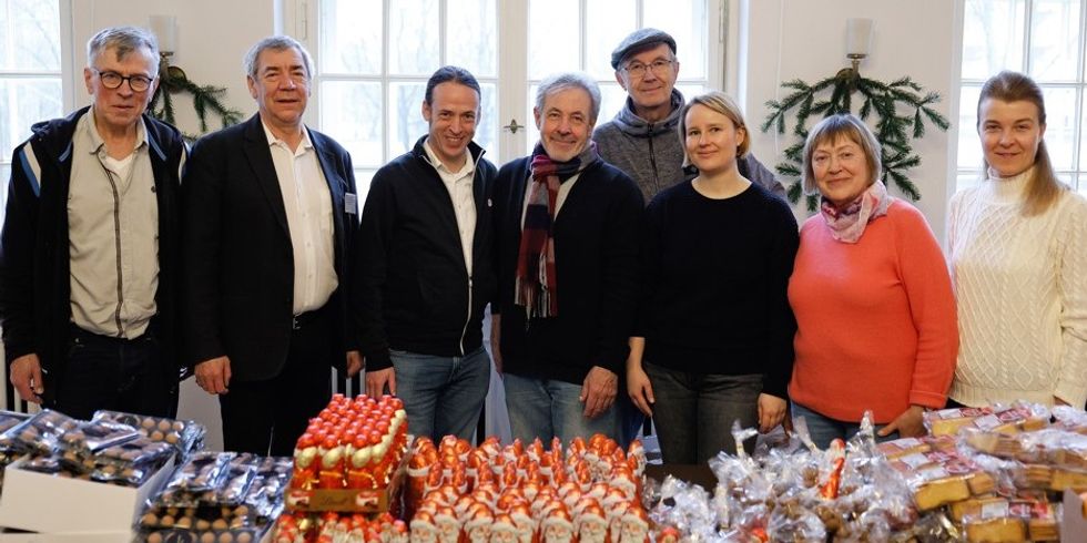 Die Seniorenvertretung Friedrichshain-Kreuzberg e.V. und freiwillige Helfer*innen vor dem Packen der Weihnachtstaschen