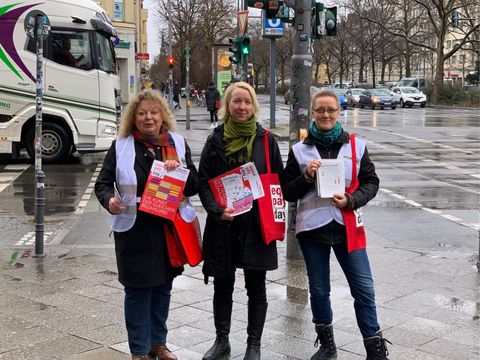 Drei Damen mit DGB-Westen und DGB-Flyer in der Hand die an der Straßenkreuzung stehen