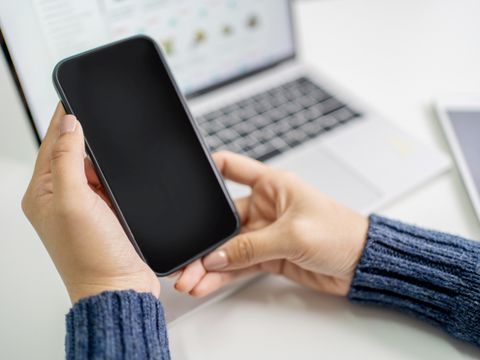 Frau hält Handy in der Hand
