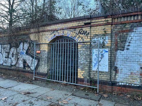 Sanierungsbedürftiger Torbogen im Nordbahnhof mit einem Absperrgatter vor dem Eingang.
