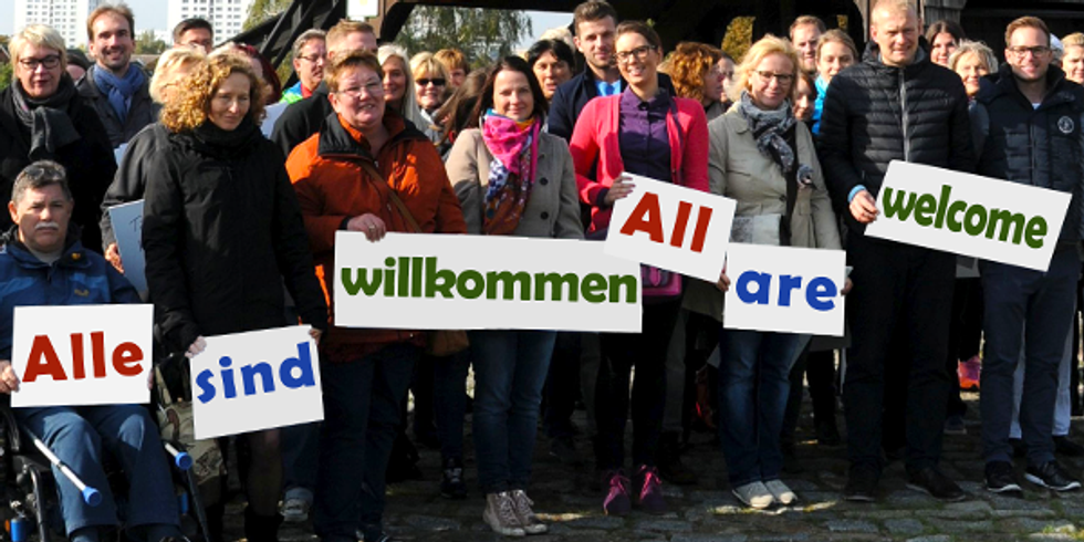 Menschengruppe hält Schildmit Beschriftungen