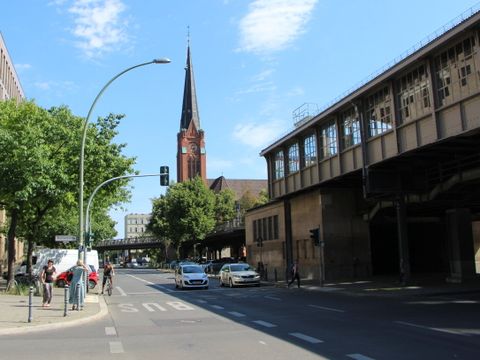 Eine mehrspurige Straße mit mehreren Fahrzeugen, im Hintergrund eine Kirche