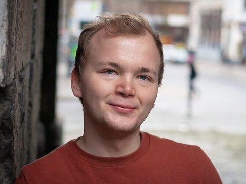 Ein Mann lächelt in die Kamera.