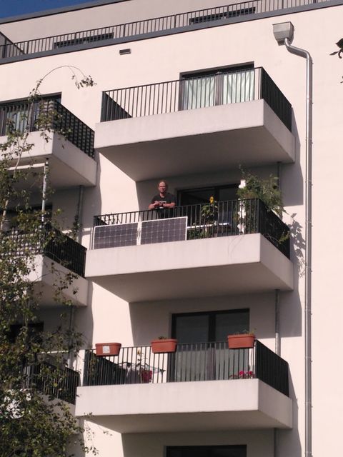 Mieter Gunnar T. auf seinem Balkon mit zwei neuen semiflexiblen Panelen. (Bild: BA Reinickendorf)