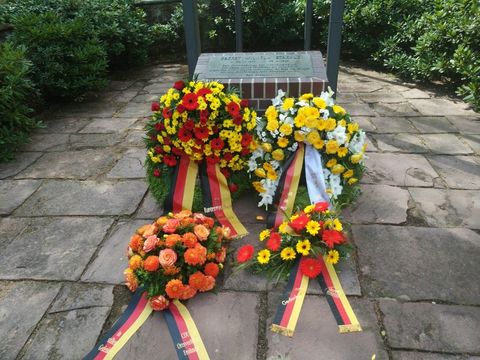 Vier Kränze liegen auf dem Boden vor dem Ehrenmal in der Invalidensiedlung