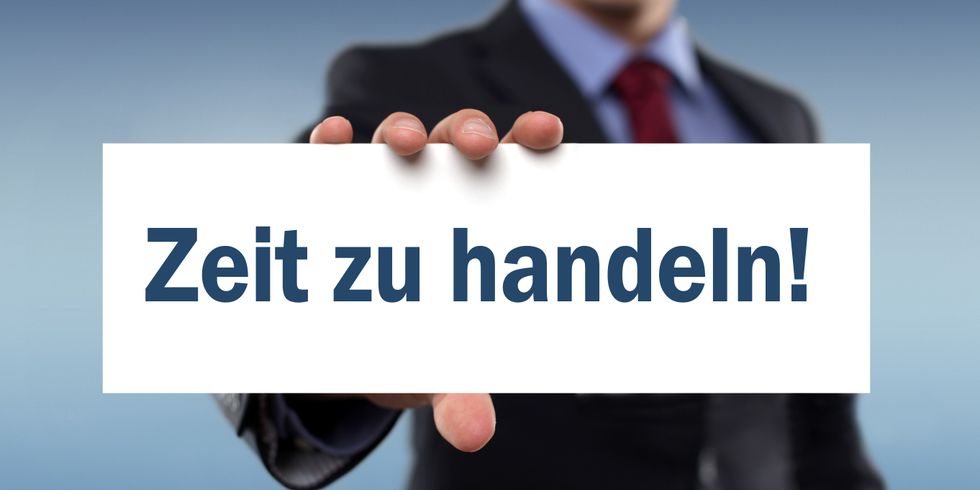 Mann hält Schild hoch mit der Aufschrift "Zeit zu Handeln"