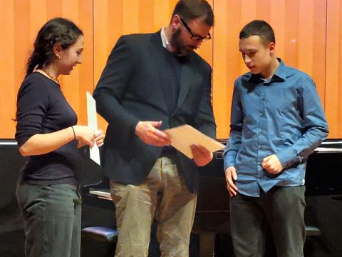 Herr Dr. Jütting überreicht Emilia und Mats Jung die Urkunde.