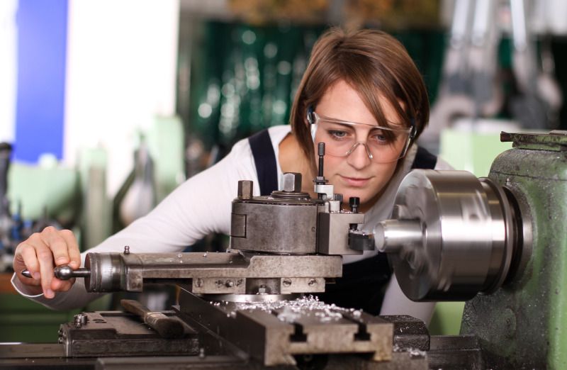 Junge Frau an der Drehmaschine