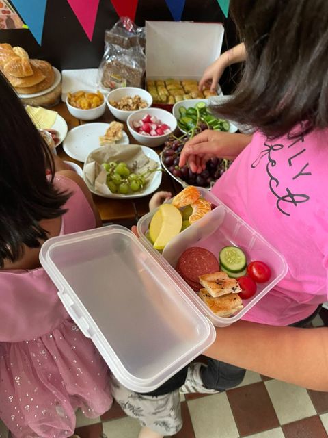 ein Kind hält eine geöffnete Brotbox in der Hand